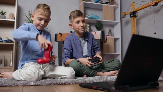 少年坐在地毯上，用操纵杆在电脑上玩游戏
