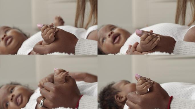 一张母亲握着新生儿手的特写镜头