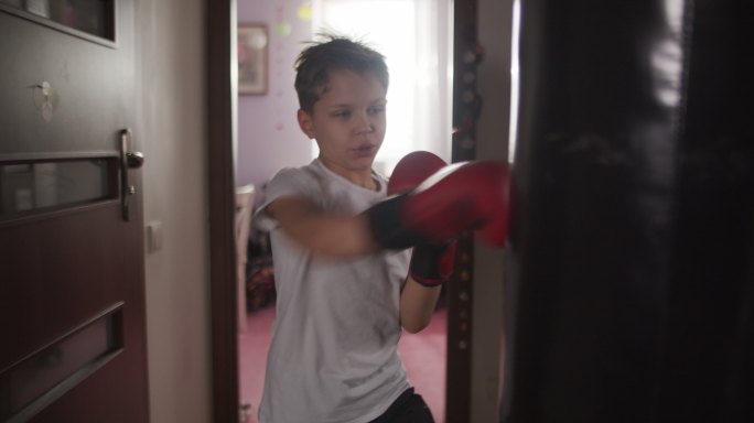 小男孩用拳击袋训练拳击