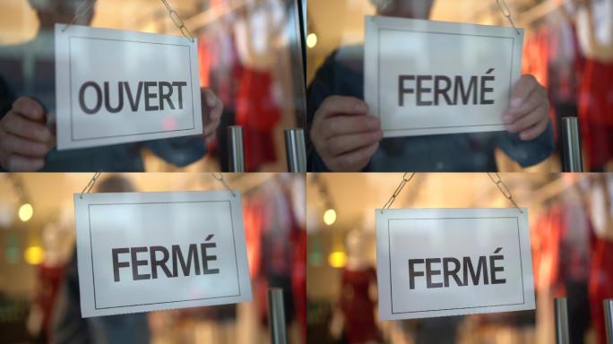 店主转向店面门上的关闭标志