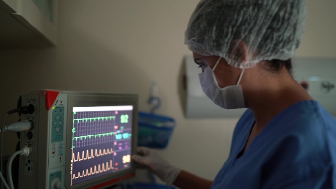 麻醉师分析医院手术中的计算机监视器