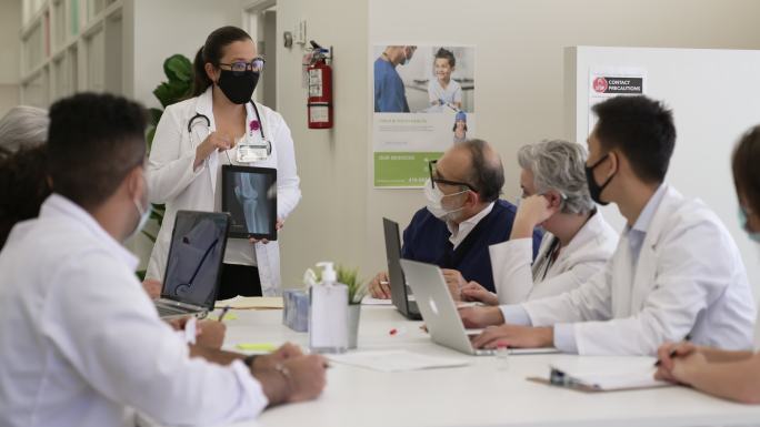 戴着防护口罩的医学生在专心教授讲课。