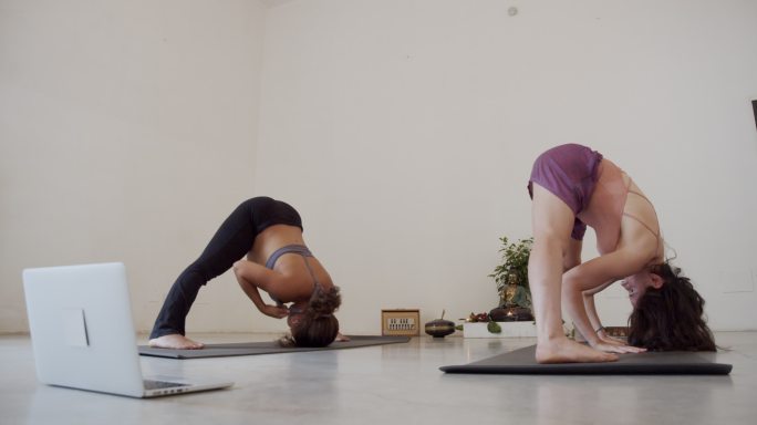 两个瑜伽女孩在网上瑜伽课上一起训练