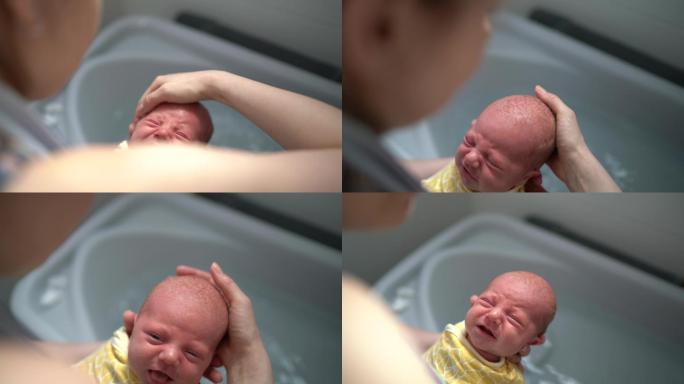 母亲给新生儿洗澡孩子微笑幸福笑容阳光灿烂