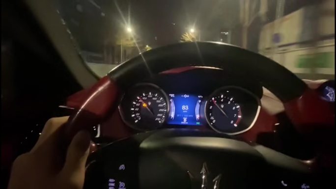 车生活：夜间惬意驾驶豪车在城市道路上穿行