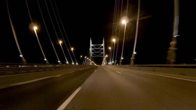 城市交通驾车第一视角开车过大桥桥上灯光照