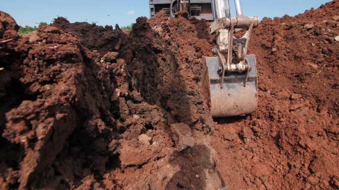 卡车在施工现场用铲斗在泥土中挖洞