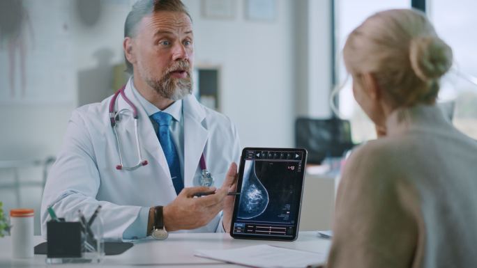 医生在电脑上向一名患者展示乳房X光结果