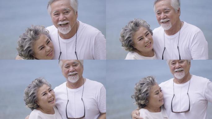 快乐的老年夫妇在海滩摆姿势