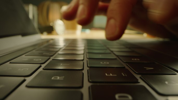特写镜头：在电脑键盘上打字的人