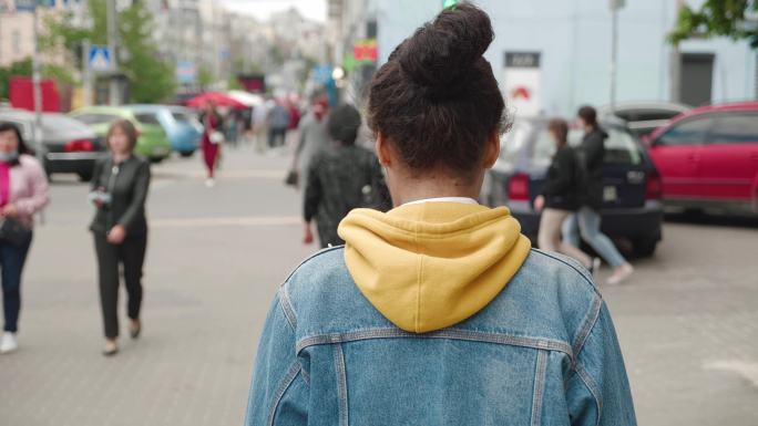 年轻女子穿着牛仔夹克在市中心漫步