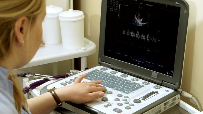 女医生用超声波设备检查病人的心脏