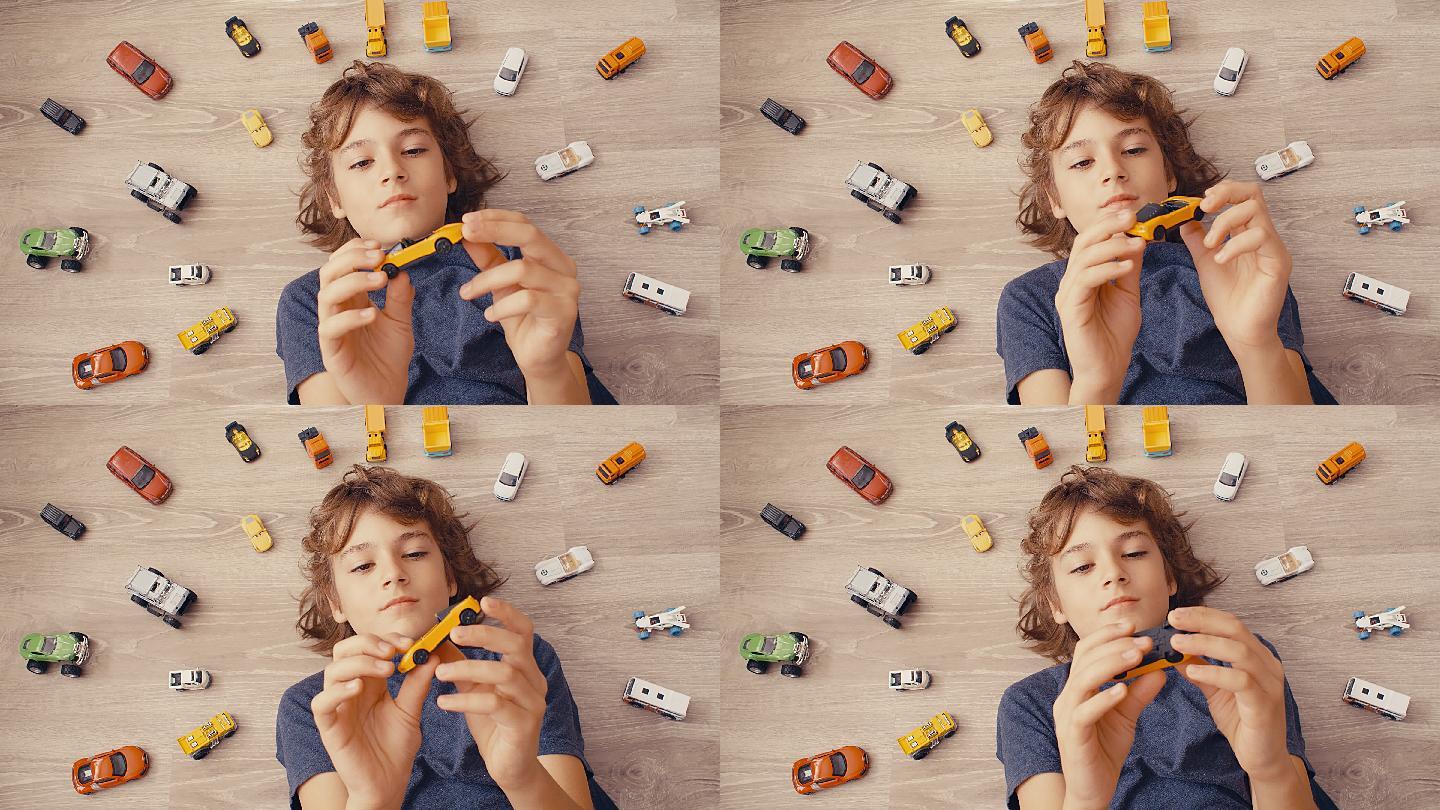 男孩躺在地上玩着玩具车
