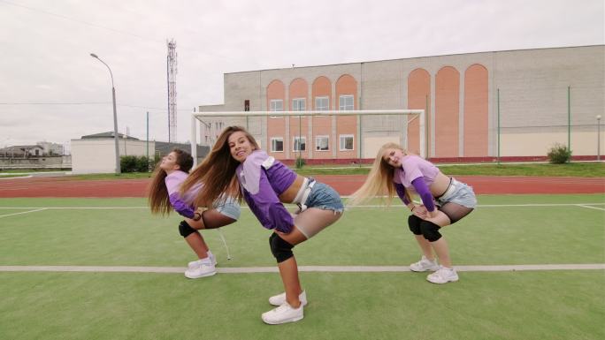 一群年轻女性在体育场户外跳嘻哈舞蹈。