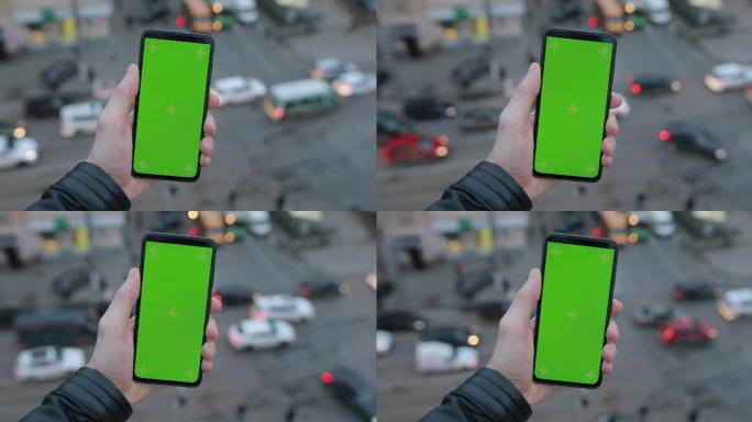 男性手持智能手机，绿色屏幕