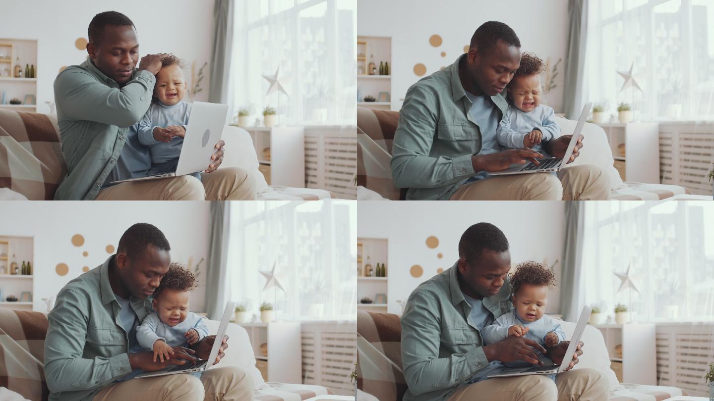 男子在照看婴儿时使用笔记本电脑