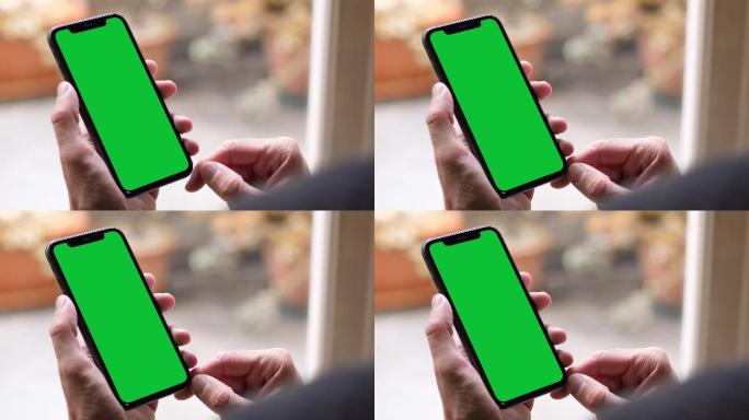 轻触并握住绿色屏幕的iPhone