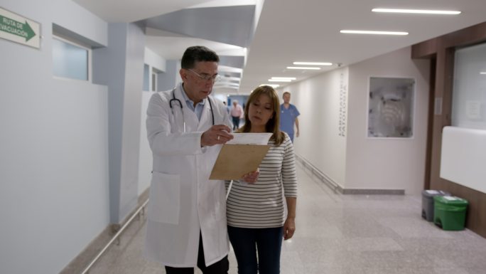 医生与一位展示检测结果的女患者交谈