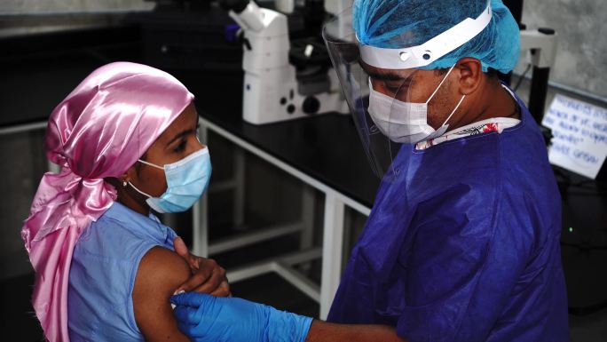 护士给年轻女性接种疫苗