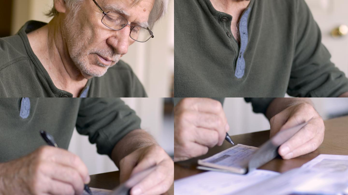 男子用钢笔在支票簿上写支票