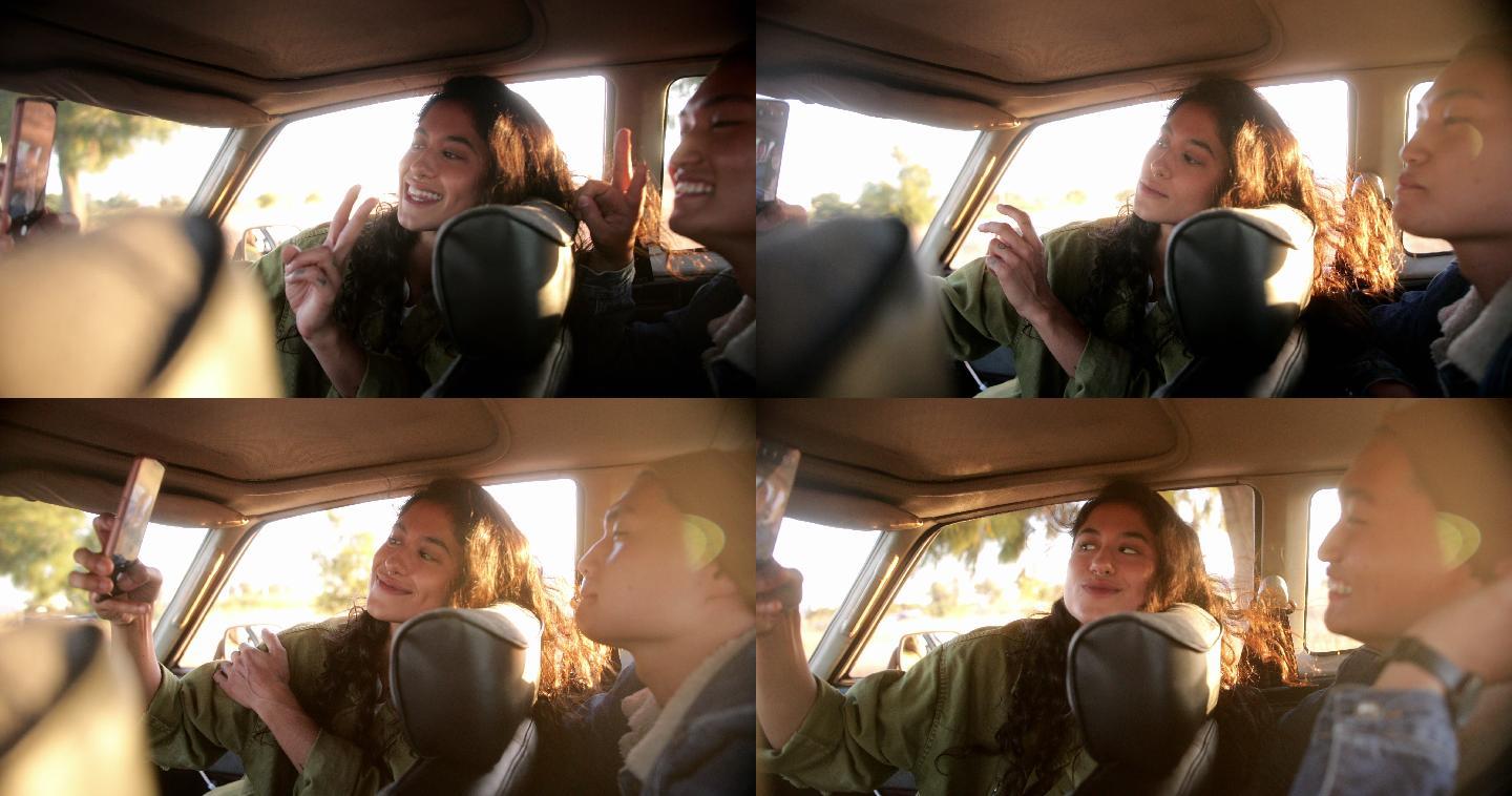 年轻的夫妇在车内用智能手机自拍