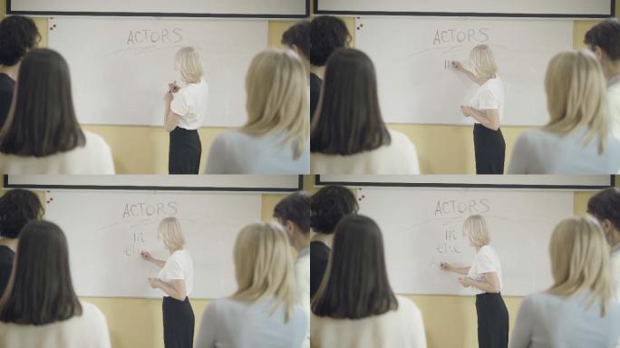 表演老师在白板上写演员的角色。
