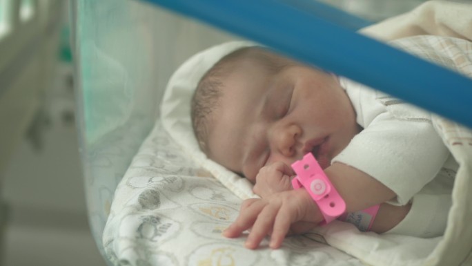 新生婴儿躺在医院的婴儿床上睡觉