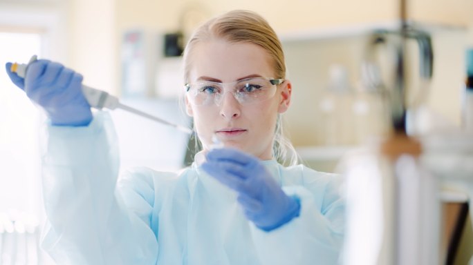 女科学家在实验室用移液管分析液体