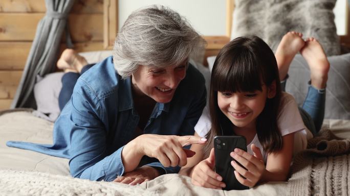祖母和小孙女用智能手机