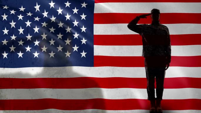 美国士兵剪影对着国旗敬礼