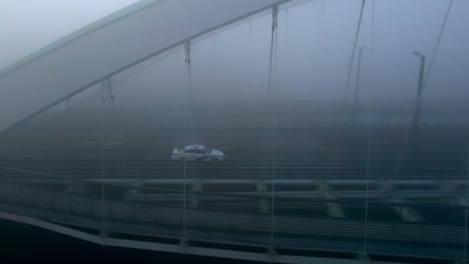 雾天警车驶过大桥