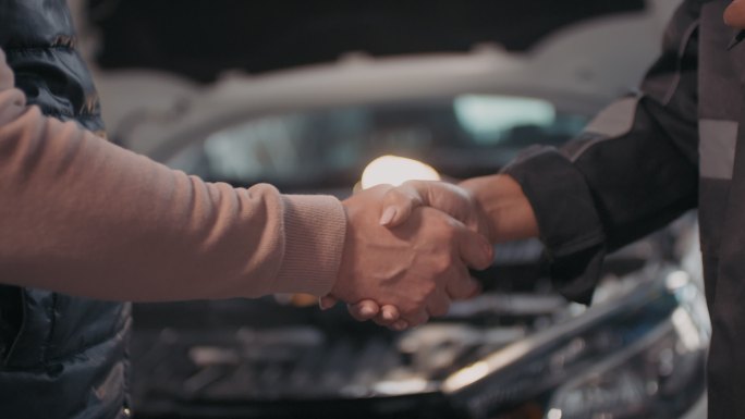 女汽车修理工与客户握手