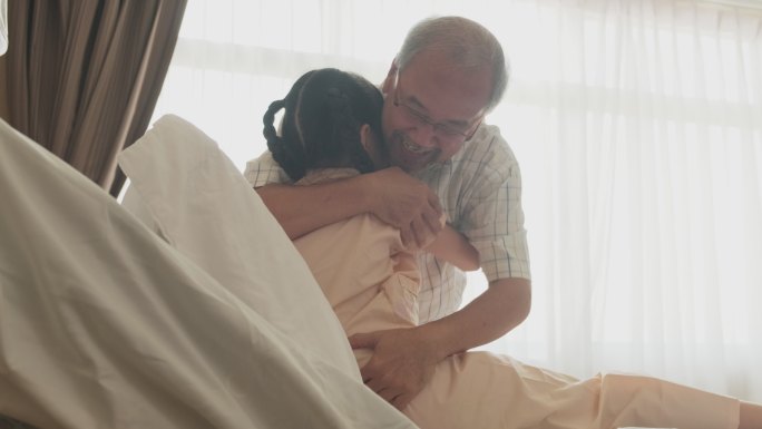 小女孩躺在病床上，父亲来了拥抱她