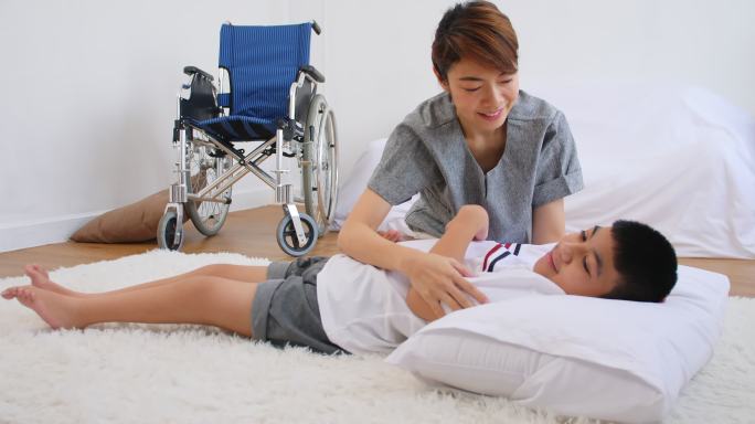 残疾儿子在母亲的照顾下通过锻炼进行治疗。