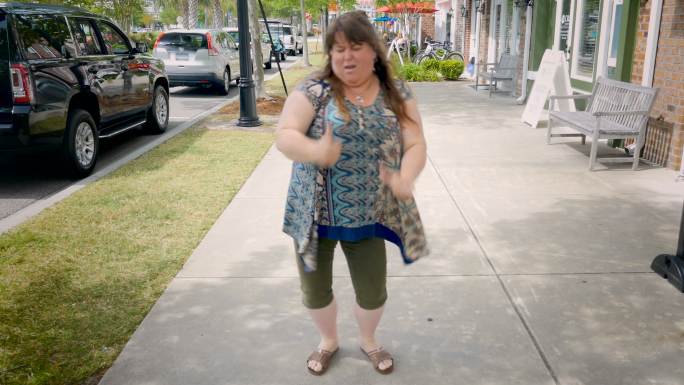 胖女人在城市人行道上跳舞