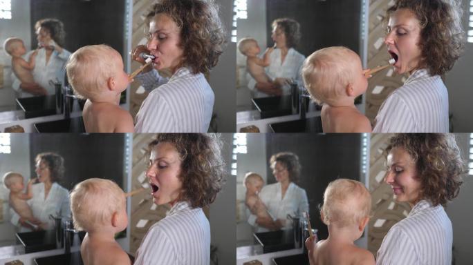 年轻的白人母亲抱着婴儿一起刷牙