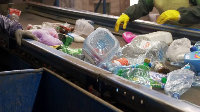 两名工人在一家回收厂分拣塑料瓶。