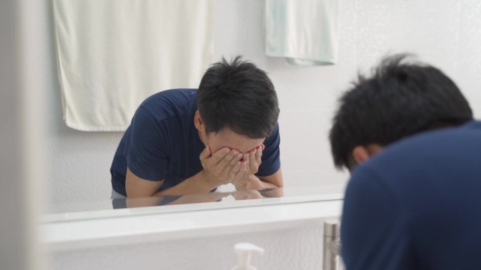 男人用纯净水洗脸以缓解疲劳。