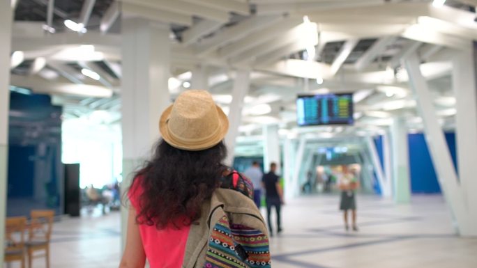 女旅客携带行李在机场候机楼行走