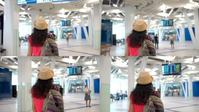 女旅客携带行李在机场候机楼行走