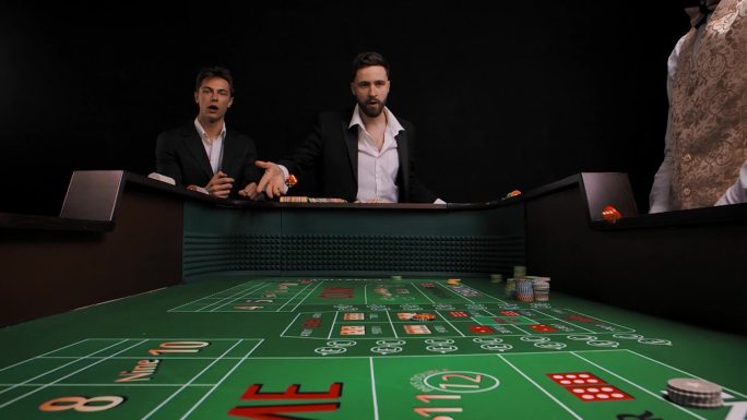 两个穿着西装的男人站在赌场桌旁