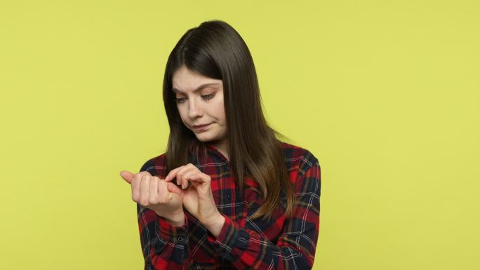 不开心的黑发女人看着自己的指甲