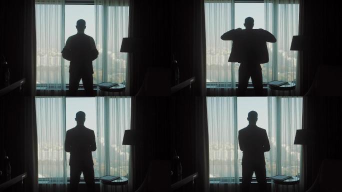 一个穿着夹克衫的男人在窗前的剪影