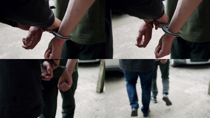 罪犯戴上手铐被带到警察局。