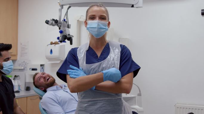 交叉双臂站在牙医室的女护士