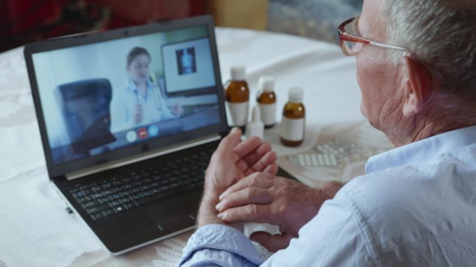 老年男性使用现视频电话咨询在线医生