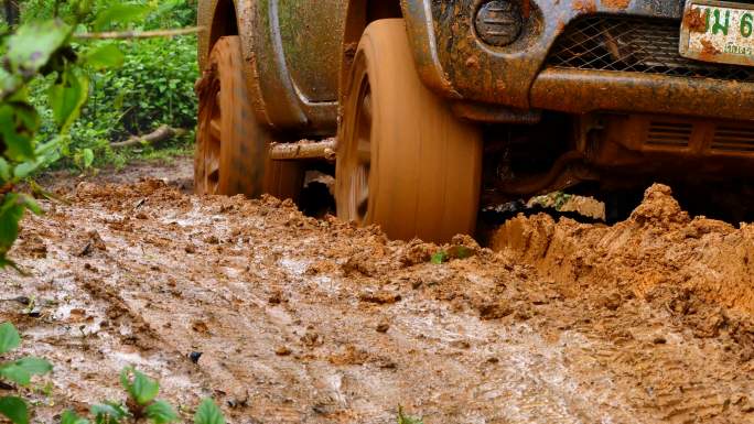 四轮驱动的皮卡车陷在泥里，试图走出泥潭。