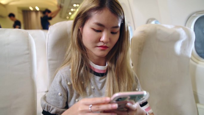 女子在飞机上使用手机