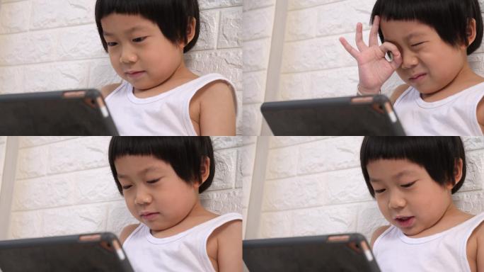 可爱的小男孩在家里使用平板电脑