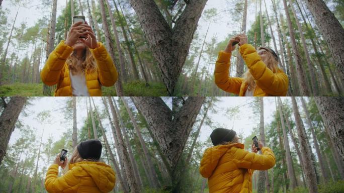 森林里的年轻女子拍照片或发出搜索信号